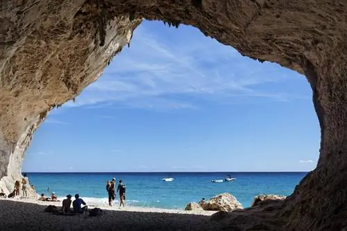 Группа людей отдыхает возле пещеры Кала Луна в Гольфо ди Орозеи, Сардиния.