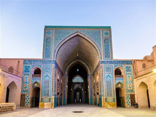 Двор мечети в иранском городе Йезд. Здание покрыто замысловатыми узорами плитки, преимущественно оттенков синего с небольшим количеством желтого.