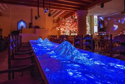 Три приподнятые конструкции, расположенные на большом столе, освещаются бело-голубым светом с проекции над головой.