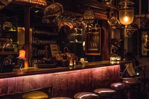 Ряд стульев стоит перед пустым баром в баре Iron Balls Distillery & Bar.