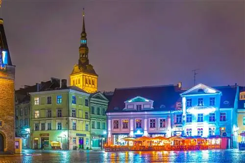 Старые здания в пастельных тонах на таллиннской площади ночью.