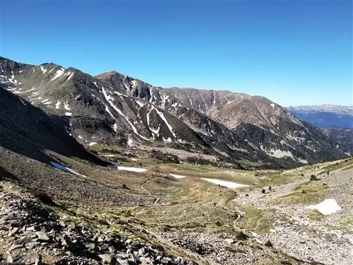 Взбираясь на Канигу, вид на бесплодную долину, окруженную горами.