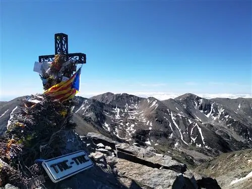 Пик Канигу с большим распятием, венчающим горный пейзаж.