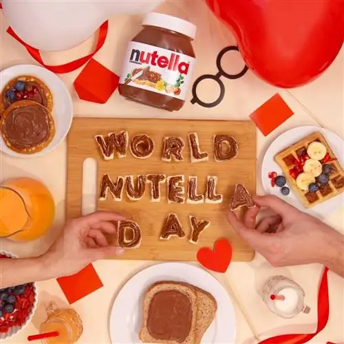 Вид сверху на стол с руками, которые держат буквы, составляющие слова World Nutella Day