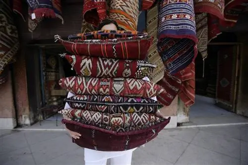 Женщина со стопкой подушек в Марракеше, Марокко