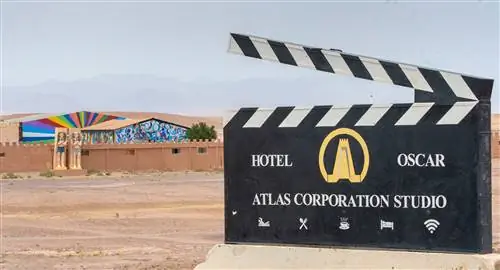 Вход в студию Atlas Studios в Марокко выглядит как большая черная доска со стилизованным изображением золотой башни, похожей на те, что можно увидеть в соседнем Айт-Бен-Хадду. За вывеской находится зубчатая стена, статуи в египетском стиле и фреска с радужными солнечными лучами.