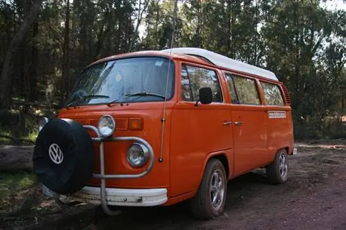 Оранжевый фургон VW Kombi во время серфинга в Австралии.