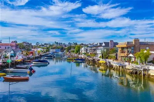 канал между рядами разноцветных домов с лодками