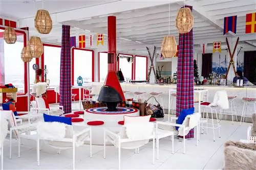 TWA Hotel Runway Chalet в баре The Pool Bar с белыми стульями, красным камином и светильниками из ротанга