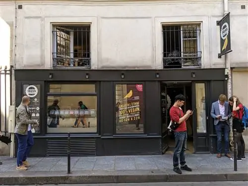 Люди слоняются вокруг выкрашенной в черный цвет витрины Hank Burger.