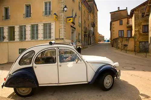 Citroën 2CV едет по французской деревне.