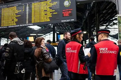Сотрудники SNCF помогают людям с информацией о расписании поездов. Сотрудники SNCF помогают людям с информацией о расписании поездов.