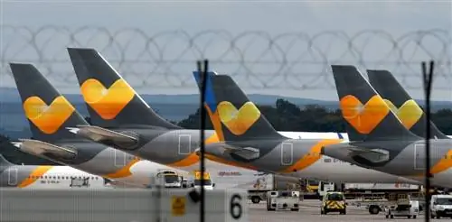Буксировка самолетов с оранжевым логотипом Thomas Cook на задней части показана в ряд.