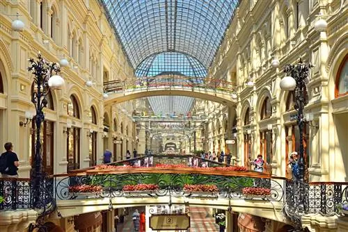 Внутренний вид широко открытого торгового центра со стеклянной куполообразной крышей наверху. Внутренний вид широко открытого торгового центра со стеклянной куполообразной крышей наверху.