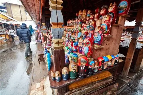Уличный прилавок, где продаются русские куклы, раскрашенные в ярко-красные и синие цвета, на некоторых из них изображены узнаваемые фигуры, например, Дональд Трамп и Мэрилин Монро. Уличный прилавок, где продаются русские куклы, раскрашенные в ярко-красные и синие цвета, на некоторых из них изображены узнаваемые фигуры, например, Дональд Трамп и Мэрилин Монро.
