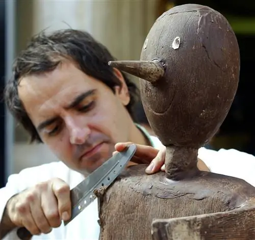 Фотография скульптора во время фестиваля Eurochocolate, вырезающего Пиноккио из плитки шоколада.