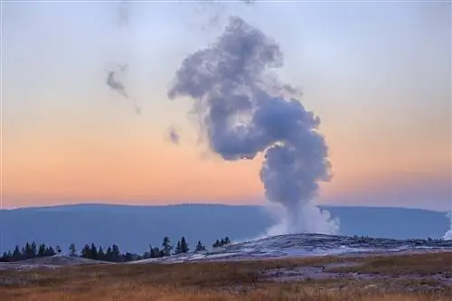 Гейзер Old Faithful в Йеллоустонском национальном парке извергается на закате в Вайоминге. Это одно из нескольких огромных природных чудес в системе национальных парков США.