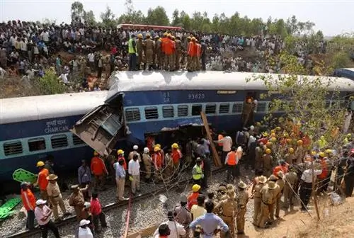 Спасатели и зрители собираются вокруг поврежденных вагонов сошедшего с рельсов поезда недалеко от Анекаля.