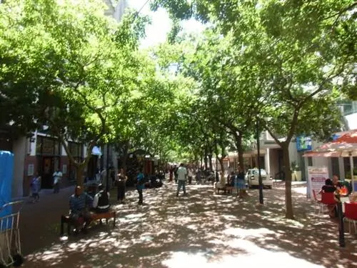 Улица торгового центра St George's Mall с красивыми деревьями, создающими тень.