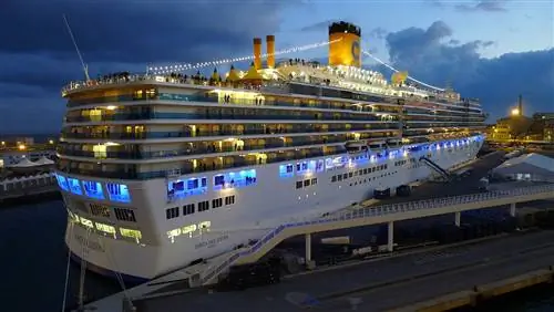 Корабль Costa Deliziosa компании Costa Cruises пришвартовался в итальянском порту на закате.