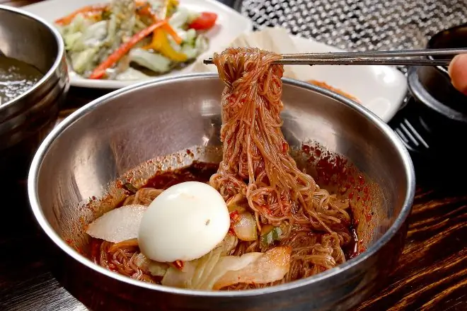 Bibim naengmyeon, охлажденный суп с гречневой лапшой и красной пастой Bibim naengmyeon, охлажденный суп с гречневой лапшой и красной пастой