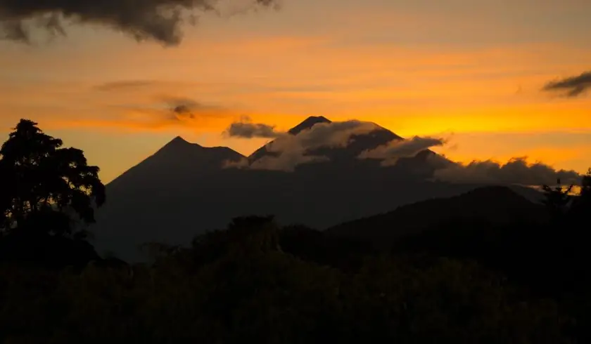 закат за тремя братьями (вулканы Пакайя, Огонь и Акатенанго) в Антигуа, Гватемала