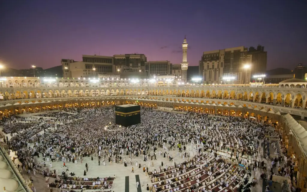 20 знаменитых путешествий по всему миру: мусульманские паломники обходят Каабу после молитвы на рассвете в Масджидил Харам в Мекке, Саудовская Аравия