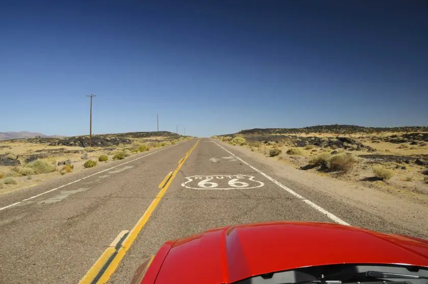 20 вещей, которые нужно сделать в вашем первом кругосветном путешествии: вид с красной машины на знаменитой трассе 66 в калифорнийской пустыне, США