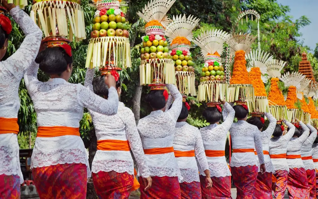 Балийские женщины в традиционном платье - саронг, несут приношения на головах для индуистской церемонии