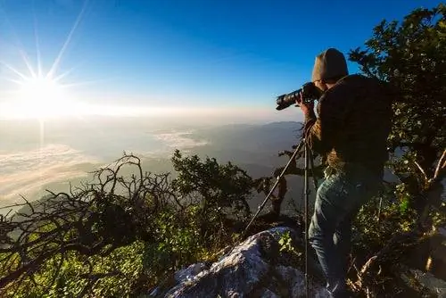 Мужчина фотографирует со штатива