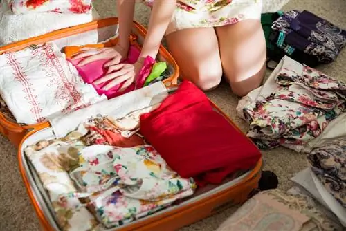 Женщина пакует чемодан