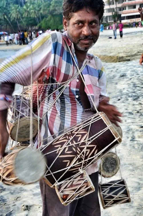 Пляжный торговец, продающий традиционные барабаны