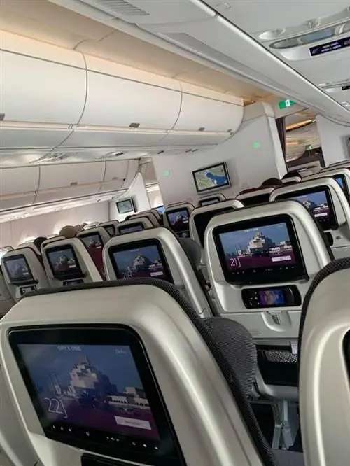 Менее чем наполовину полный самолет летит в Доху, нашу остановку.