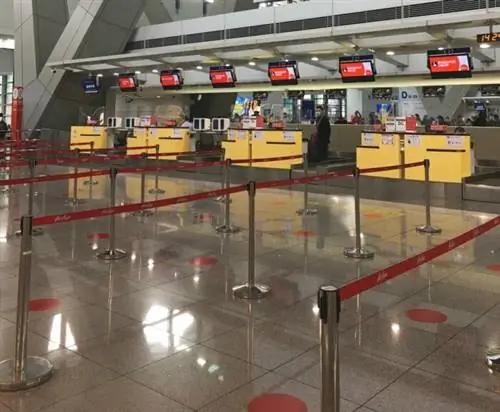 Стойки регистрации AirAsia в Терминале 3 NAIA с указателями физического дистанцирования.