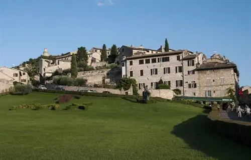 Зеленая лужайка отделяет церковь от домов старого города.