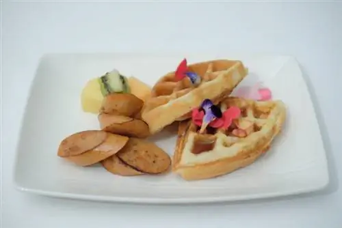 Куриные колбаски и вафли убе Ломтики куриных колбасок-гриль и вафли с начинкой убе, подаются с фруктовой смесью