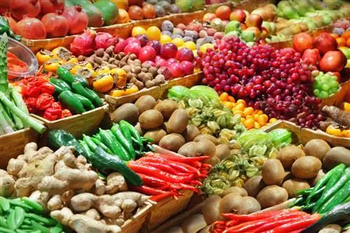 Адиса / Shutterstock. Красивый красочный прилавок с фруктами и овощами на рынке.