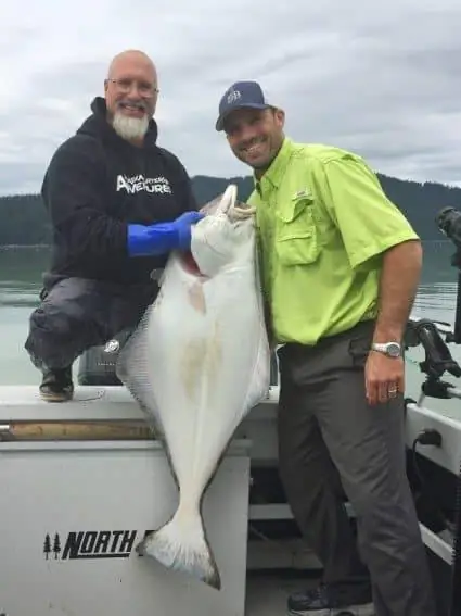 Джон Йегер, владелец компании Alaska Charters and Adventures, держит в руках 40-килограммового палтуса Пайка Пикетта.