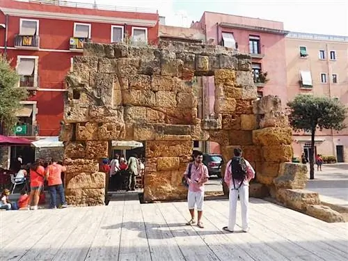 Два Кастельера стоят перед древнеримской стеной, которая сохранилась в старом городе Таррагоны.