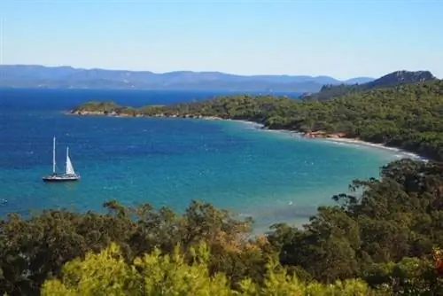 Пляж Нотр-Дам на Поркереле с яхтой вдалеке.