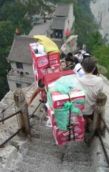 Носильщик тащит тяжелый груз.