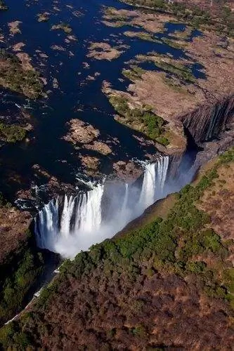 Аэрофотоснимок водопада Виктория, сделанный чрезвычайно смелым Джонатаном Дейлом, который высунулся из открытой двери вертолета, чтобы сделать этот снимок.