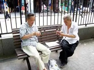 Двое мужчин играют в карты в парке