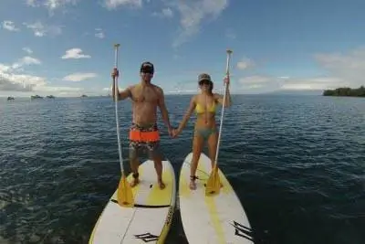 Пара держится за руки во время катания на байдарках. Мауи Stand Up Paddle Boarding фото. Пара держится за руки во время катания на байдарках. Мауи Stand Up Paddle Boarding фото.