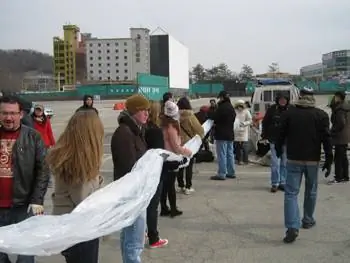 Волонтеры помогают разложить гигантский пластиковый шар и носки на нем.