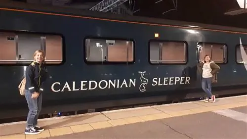 Возле одного из темно-синих вагонов Caledonia Sleeper на вокзале.