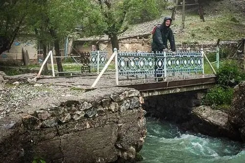 Поход по Таджикистану: переход по мосту под проливным дождем в горах.