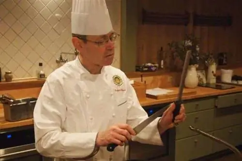 Шеф-повар Роберт Барраль на своей кухне в своем высоком колпаке.