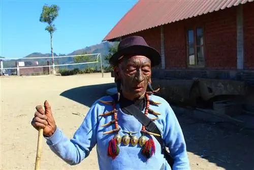 Один из бывших охотников за головами Нагаленда гуляет по деревне. Он носит рога в обоих ушах и типичное ожерелье.