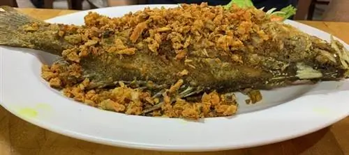 Вкусный свежий морской окунь на гриле с жареной куркумой в ресторане Bung Roon.